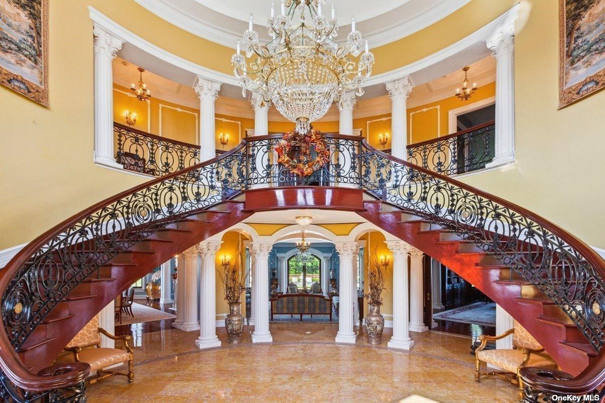 Foyer with a chandelier and grand stairs.