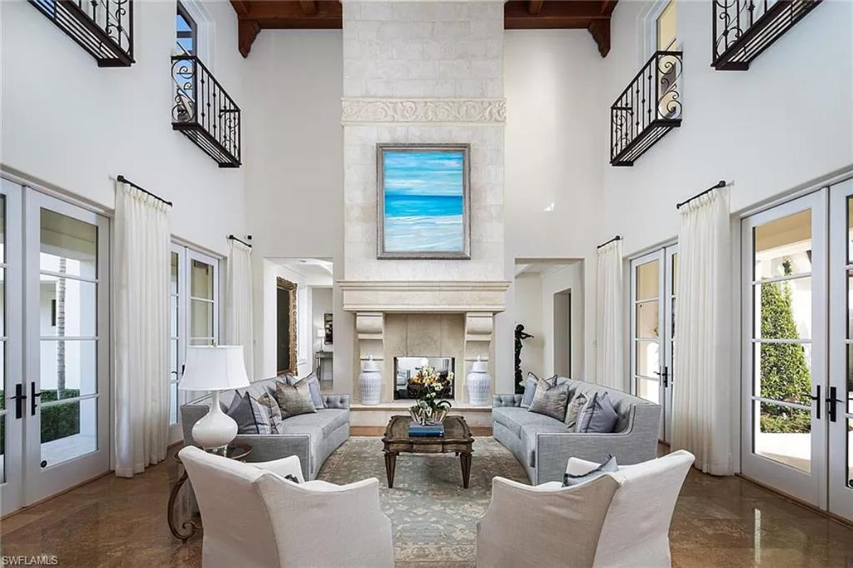 Living room with marble tiles, a fireplace and glass doors.