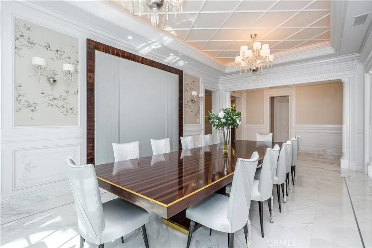Dining room with a large wood table and a chandelier.