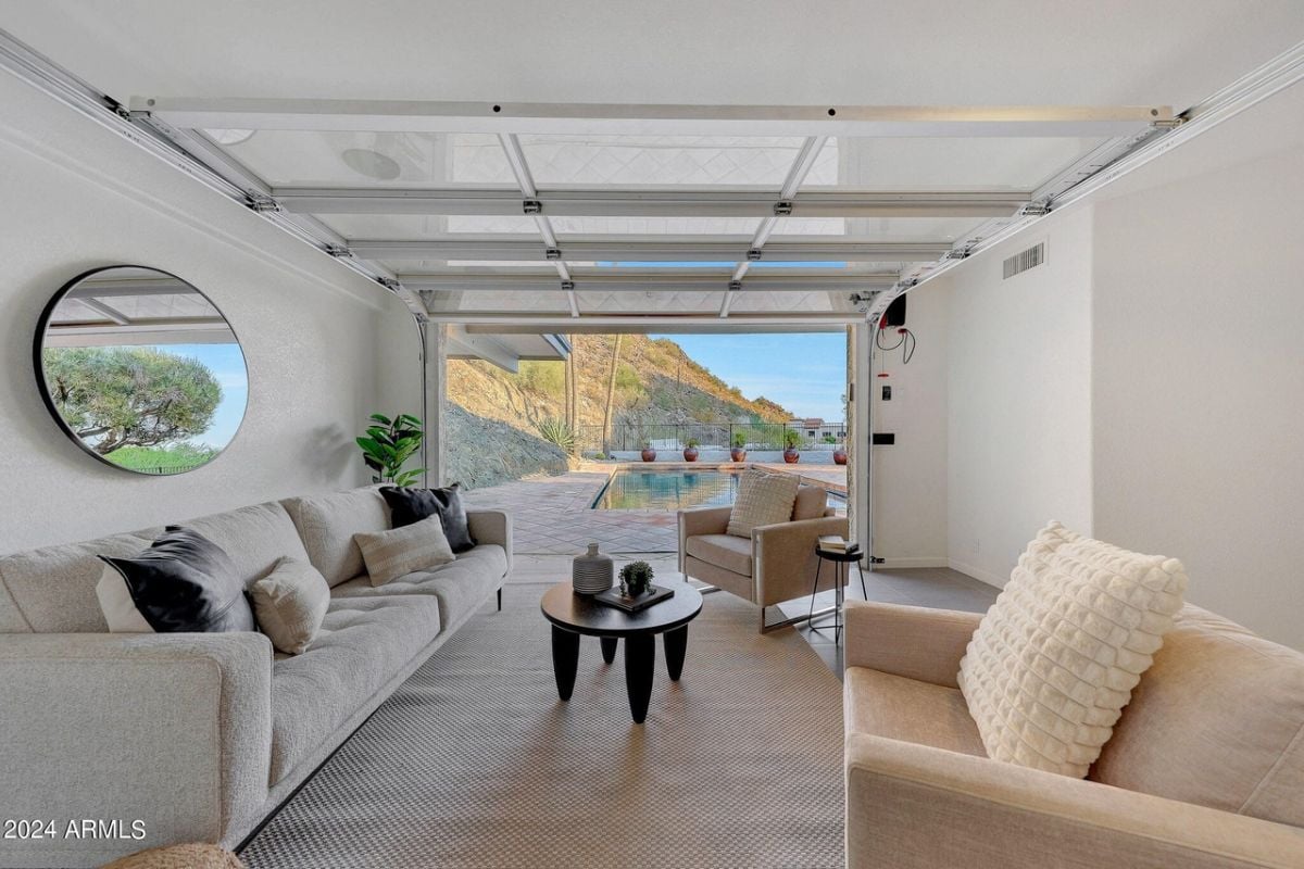A living room with a rug, couch, chairs, and a coffee table.