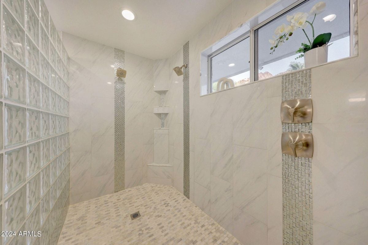 A bathroom with a shower room featuring tiled walls.