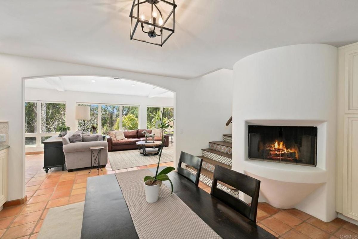 a dining area with fireplace and chandelier