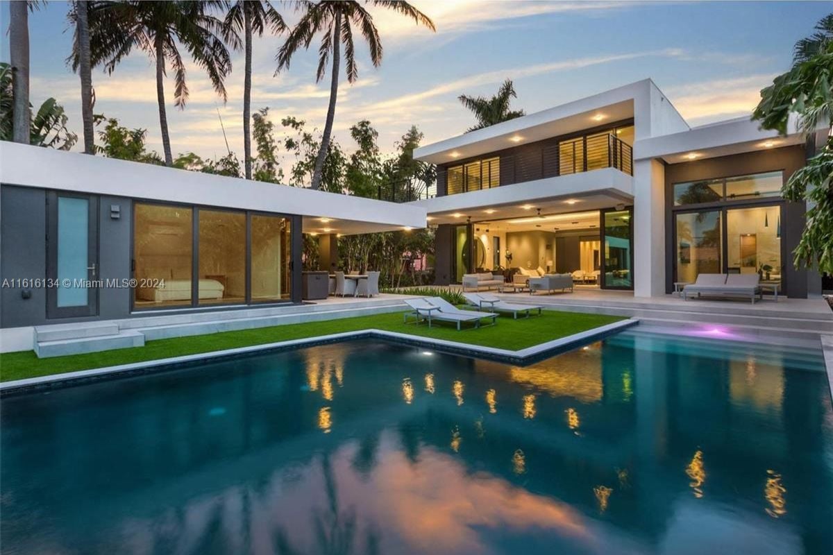 A swimming pool with chairs on the poolside.