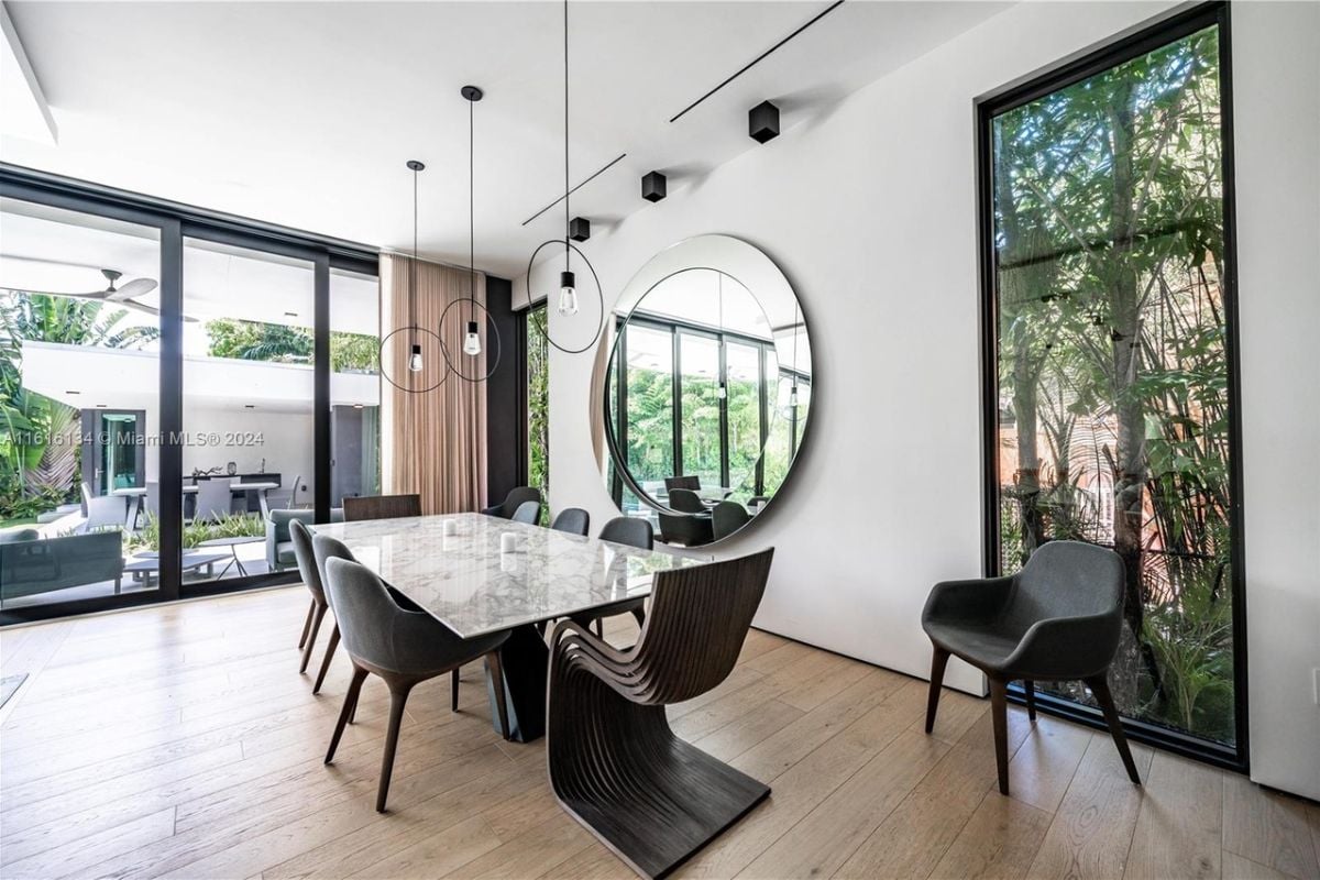 A dining area with a mirror and a dining table surrounded by chairs.