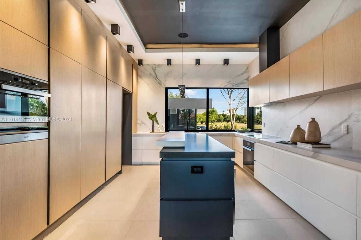 A kitchen with countertops, a window, and cabinets.
