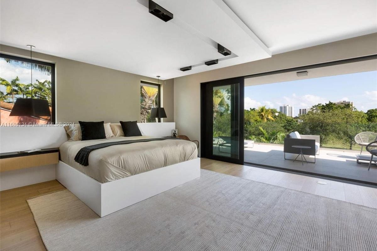 A bedroom with a bed, windows, and a rug.