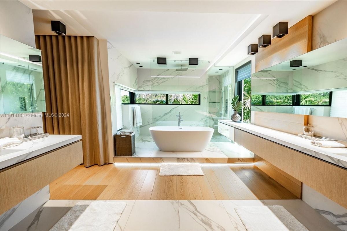 A bathroom with countertops, cabinets, tiled walls, and a bathtub.