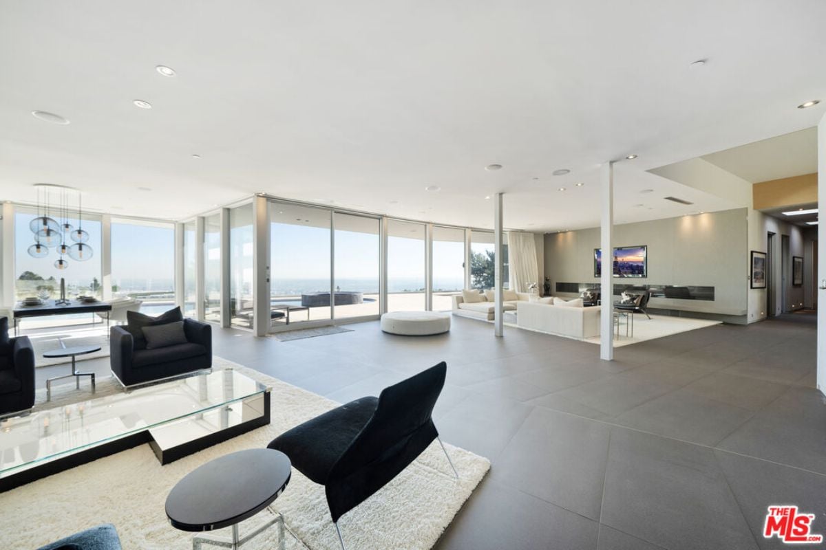 A living room with a rug, chairs, and a glass center table.