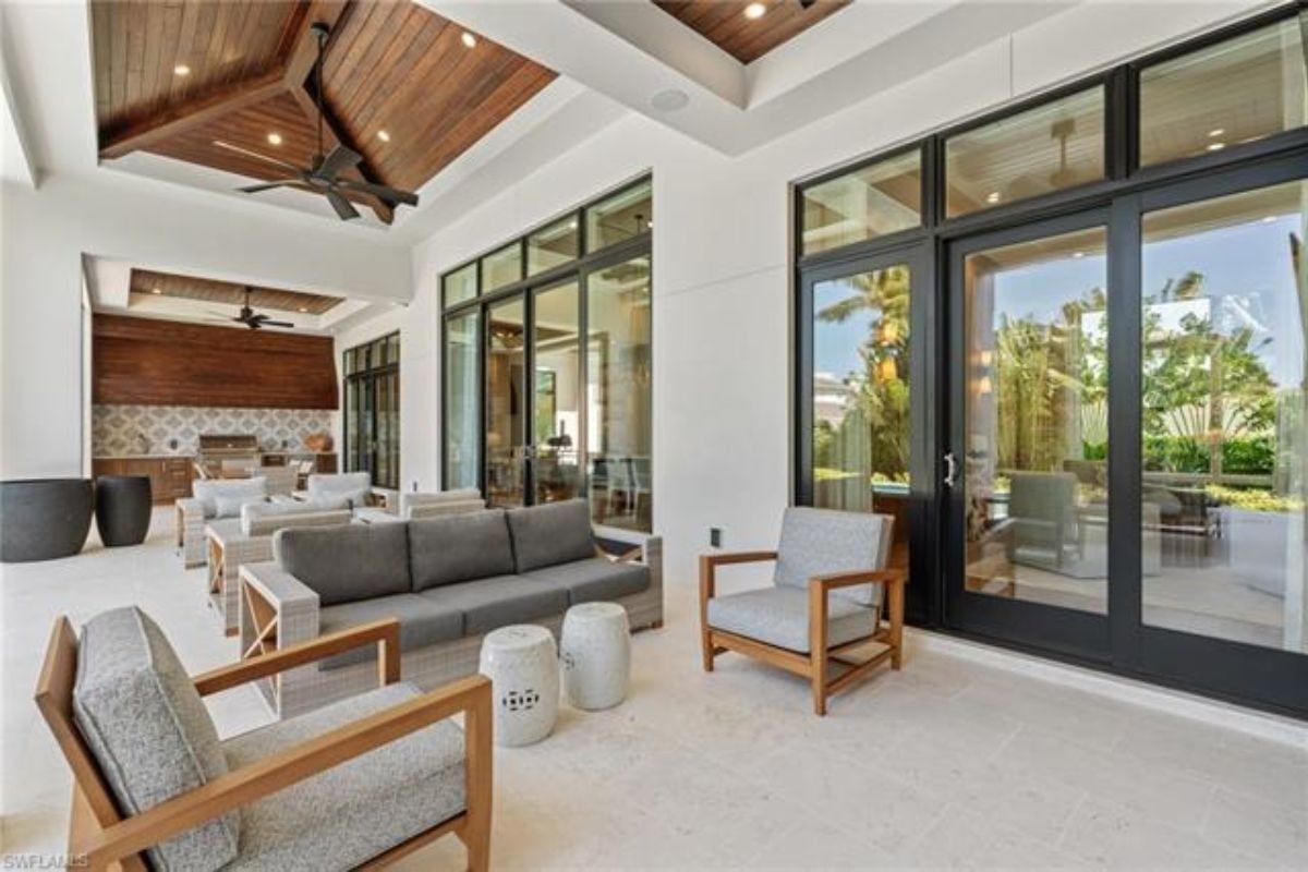An outdoor living space with couches, chairs, and a dining table surrounded by chairs.