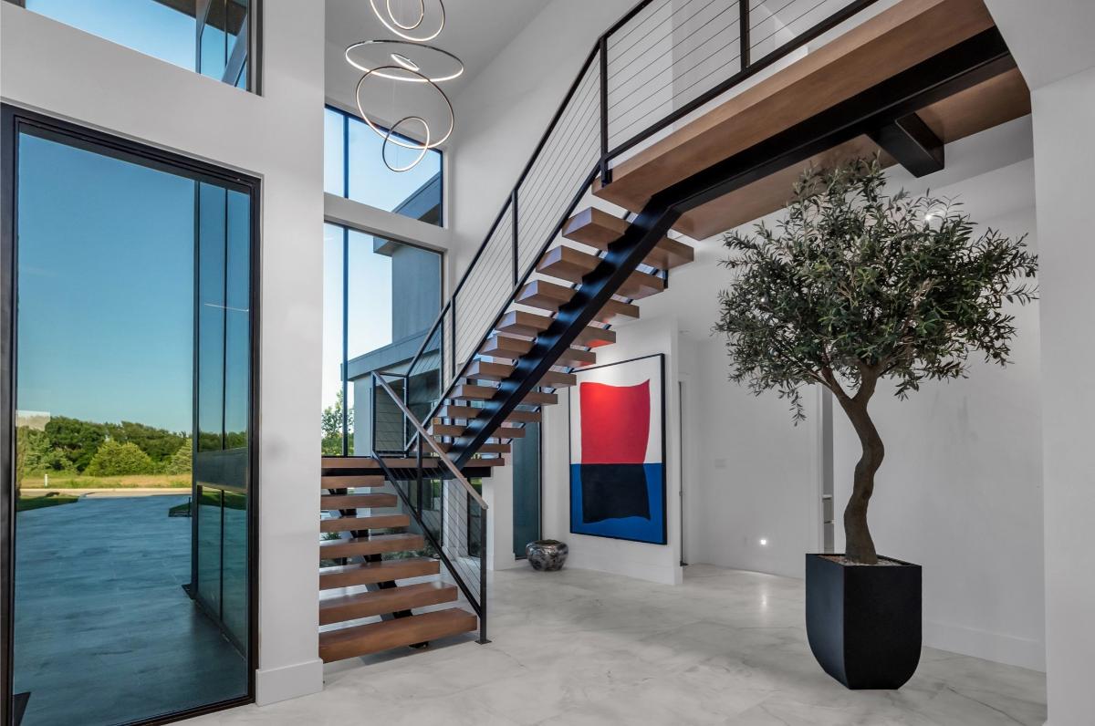 Foyer with ceramic tiles and stairs.