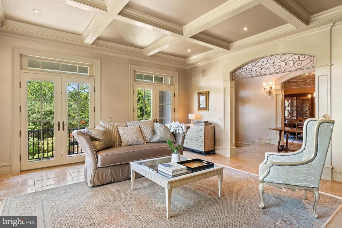 Living room with glass doors and coffered ceilings.