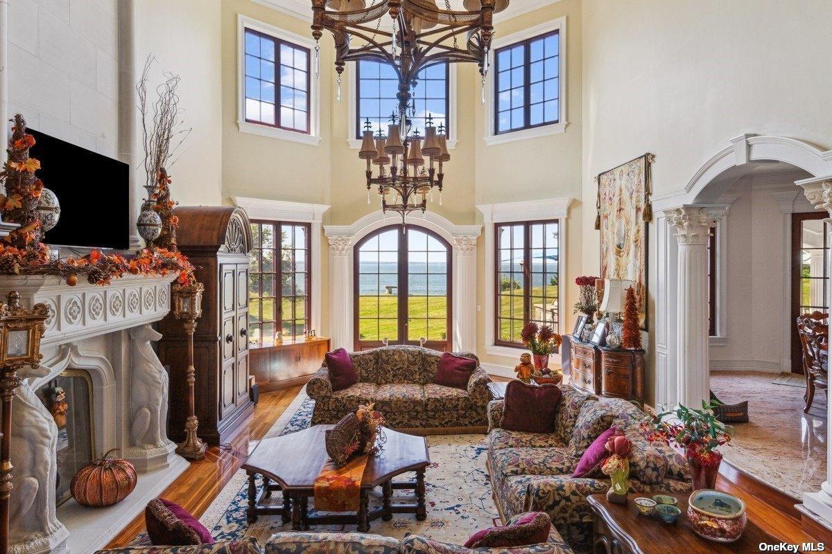 Living room with couches, a fireplace and chandeliers.