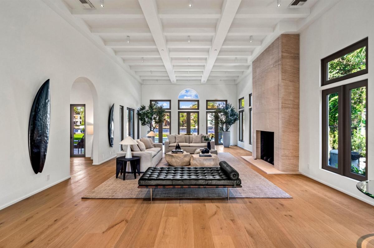 Living room with couches, coffered ceiling and a fireplace.