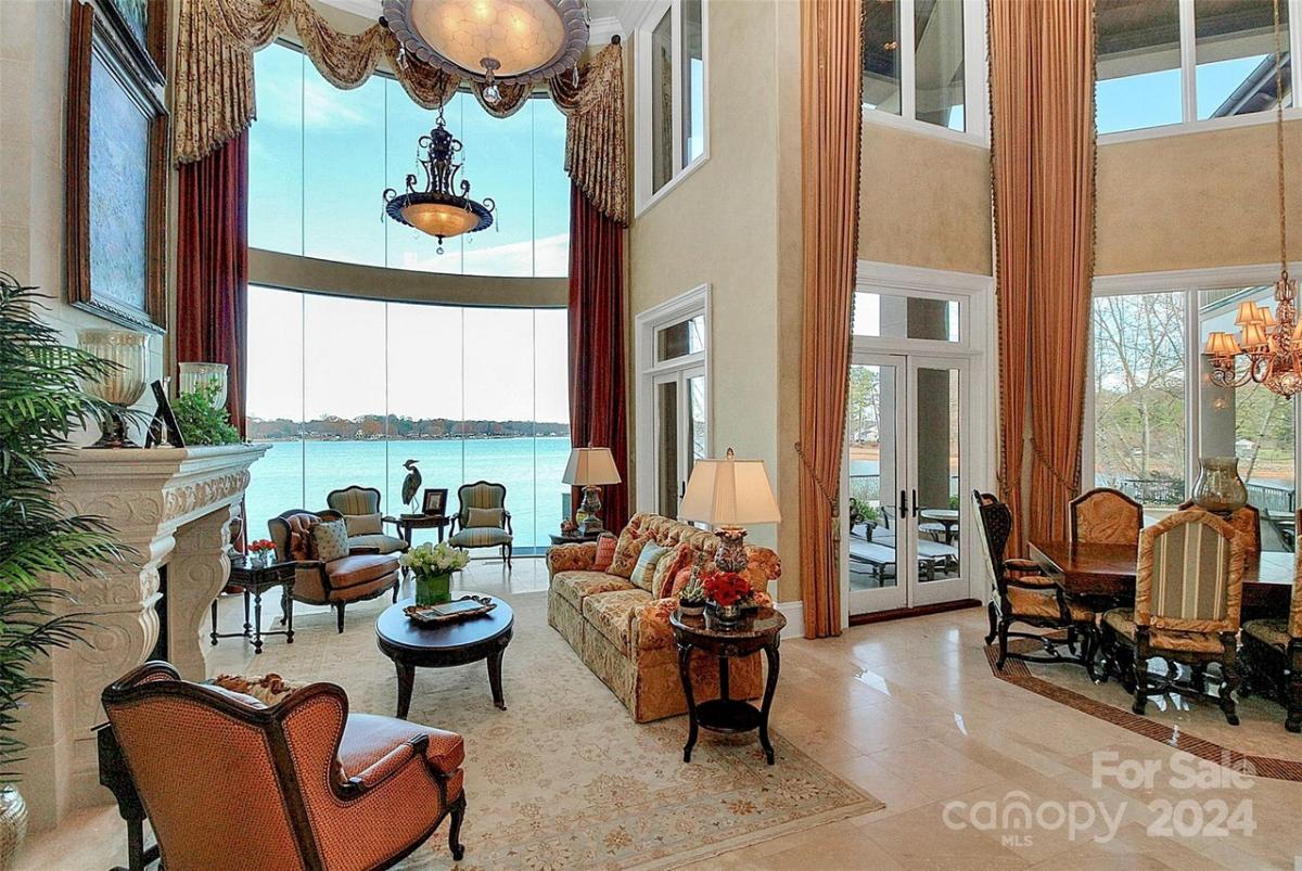 Living room with a fireplace and floor-to-ceiling glass walls.