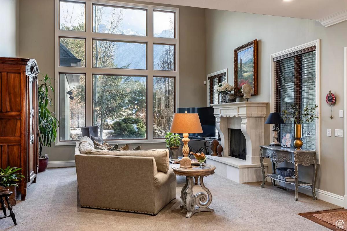 Living room with glass windows and a fireplace.