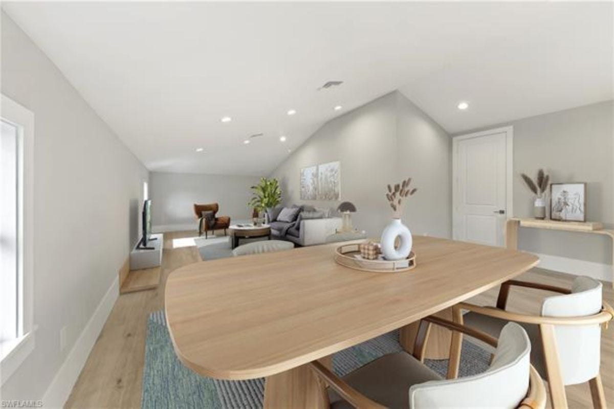 A dining area with a rug and a dining table surrounded by chairs.