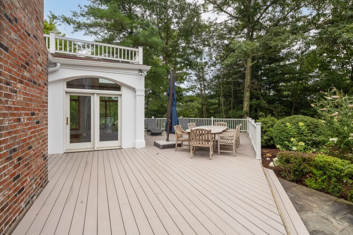 A wooden deck with a table surrounded by chairs.