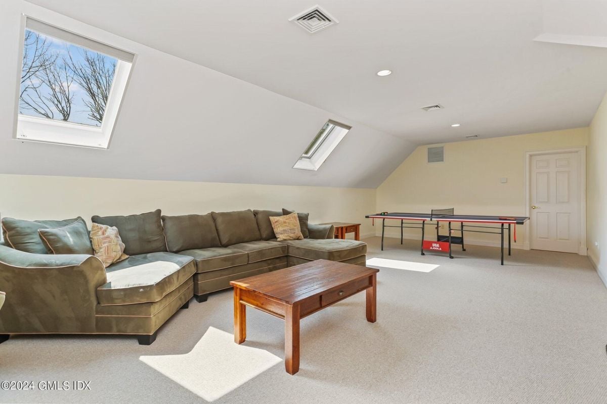 The game room features windows, a table tennis setup, a couch, and a center table.