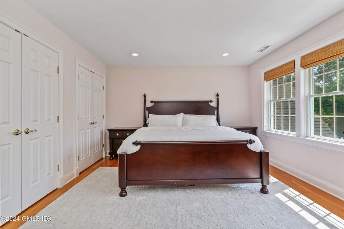 The bedroom includes a bed, windows, a rug, and nightstands.
