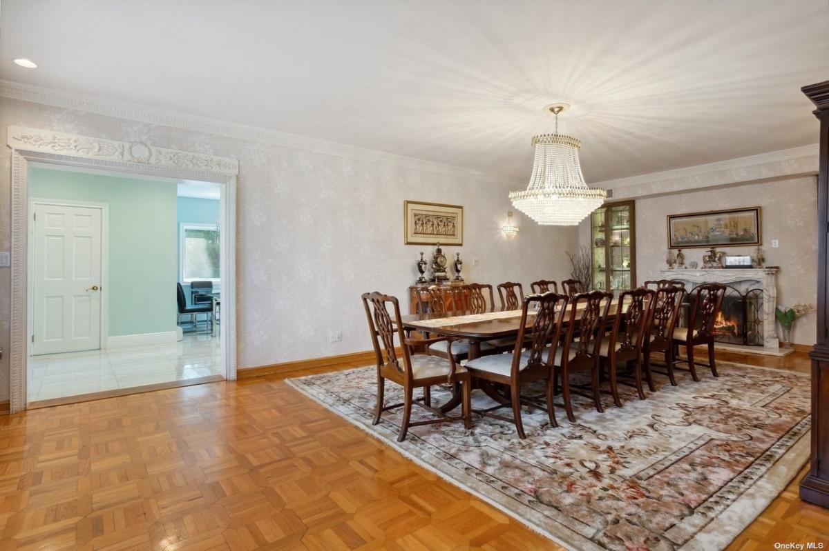 Dining room with a large table and a chandelier.