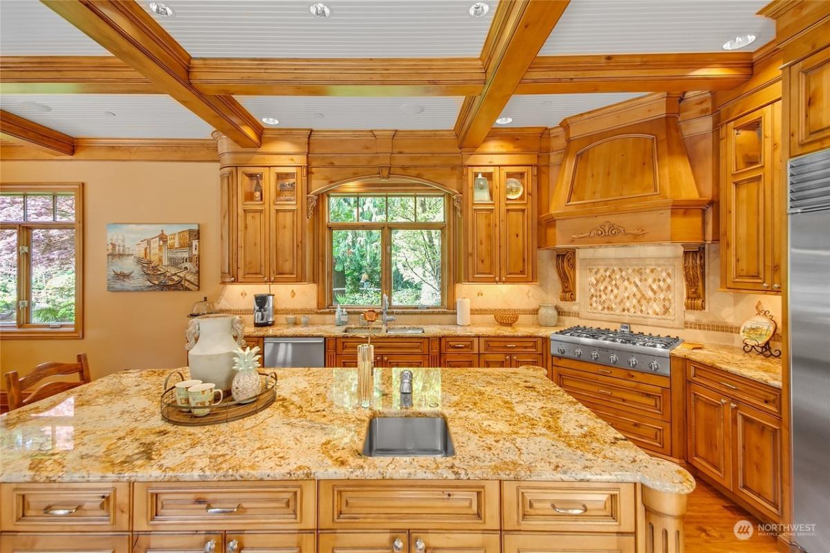 Kitchen with custom cabinetry, coffered ceilings and a center island prep area.