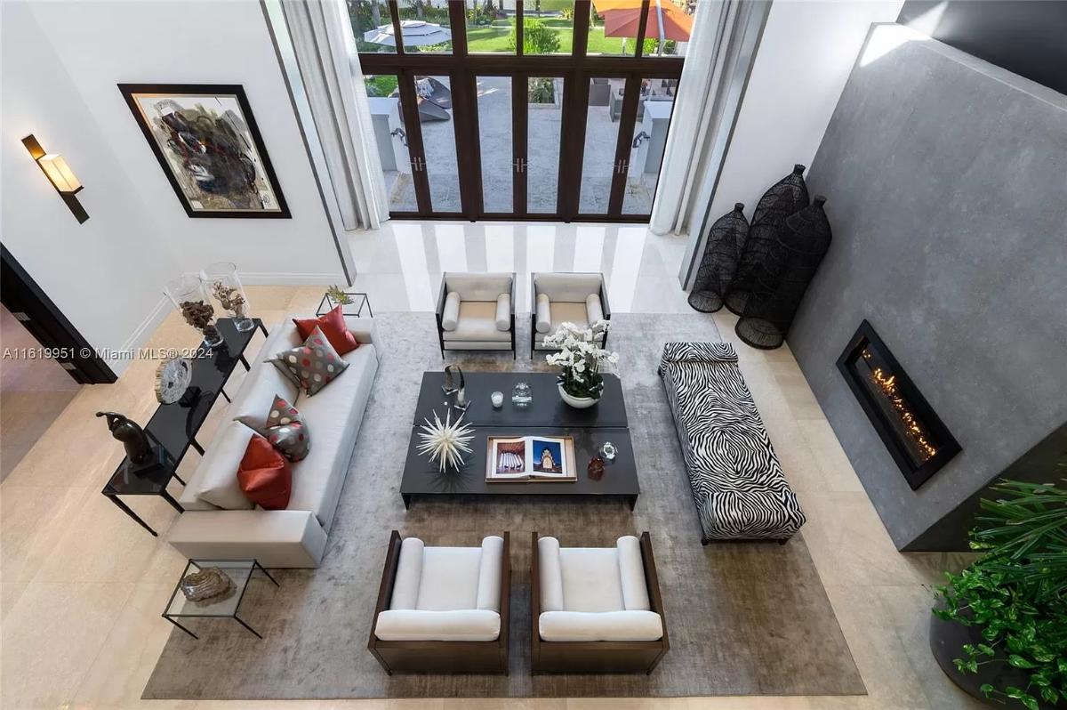 Living room with soaring ceilings, couches and a fireplace.