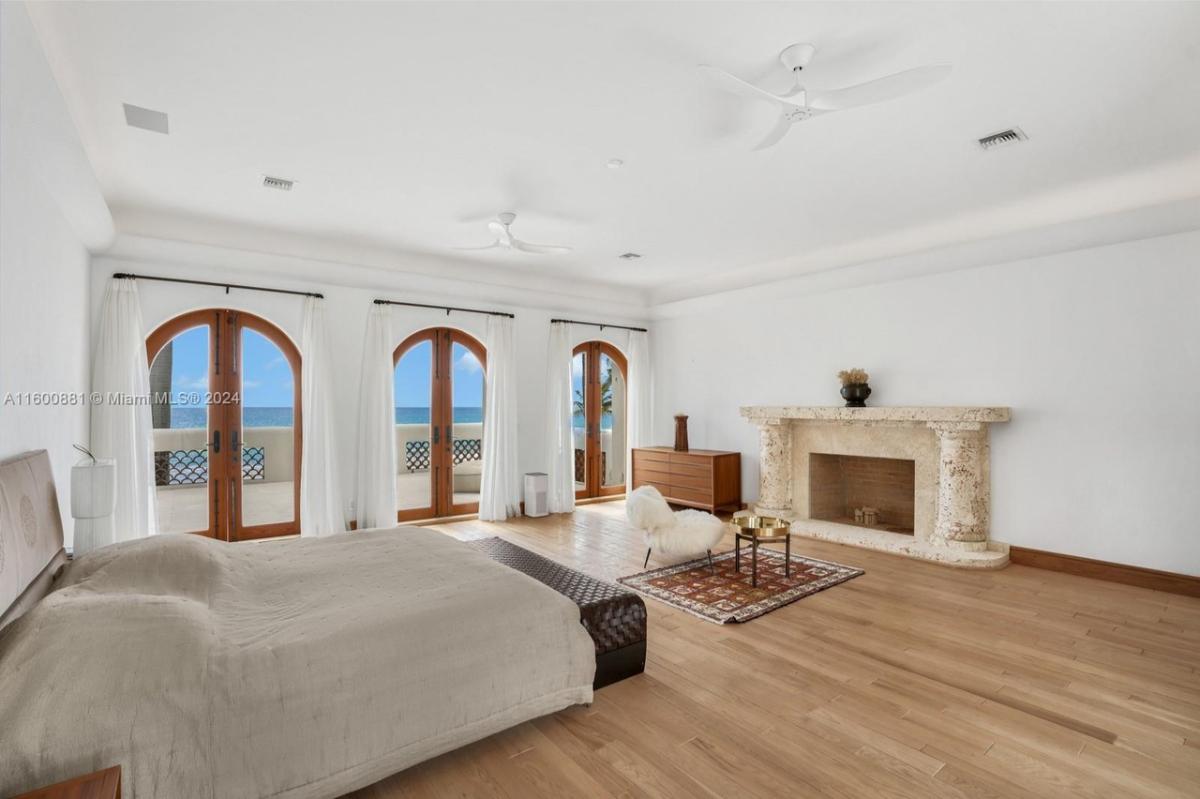 Bedroom with hardwood floors and a fireplace.