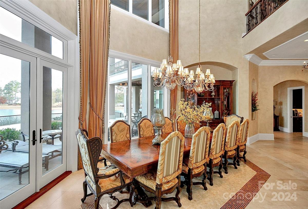 Dining room with chandeliers and a large wood table.