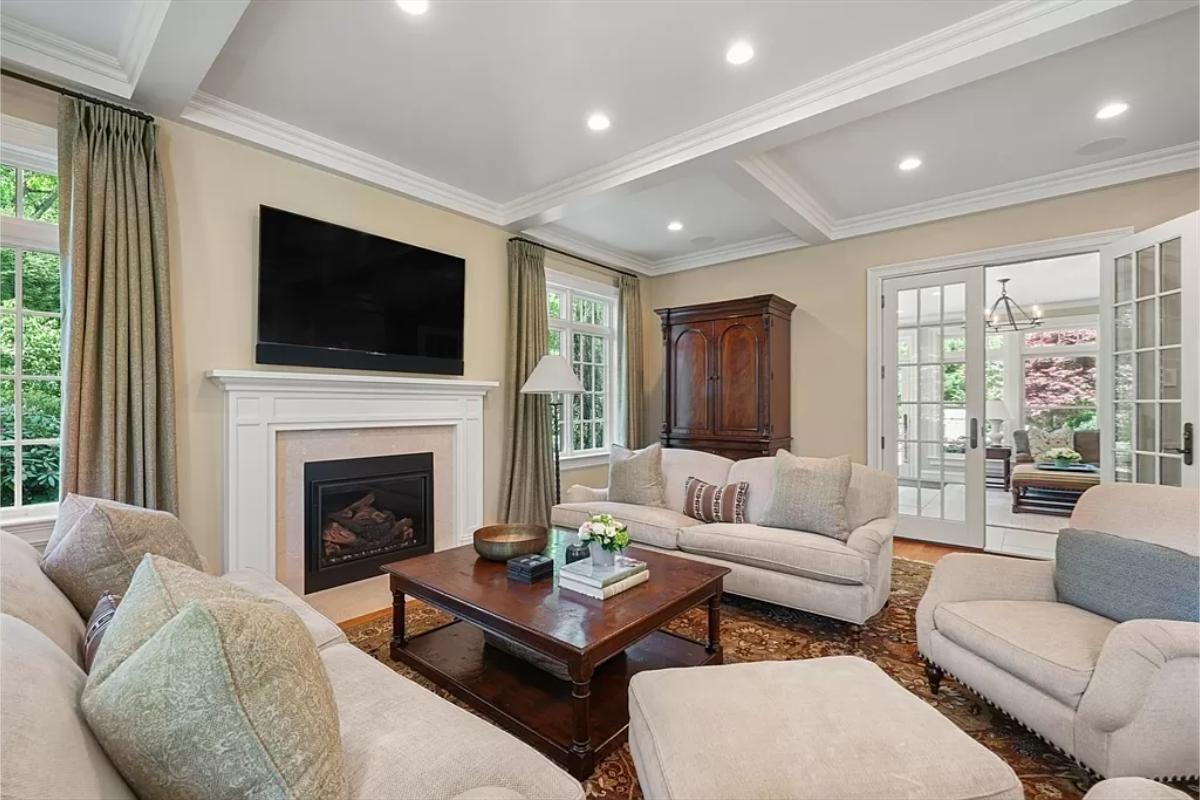 Living room with couches, a fireplace and custom lighting.