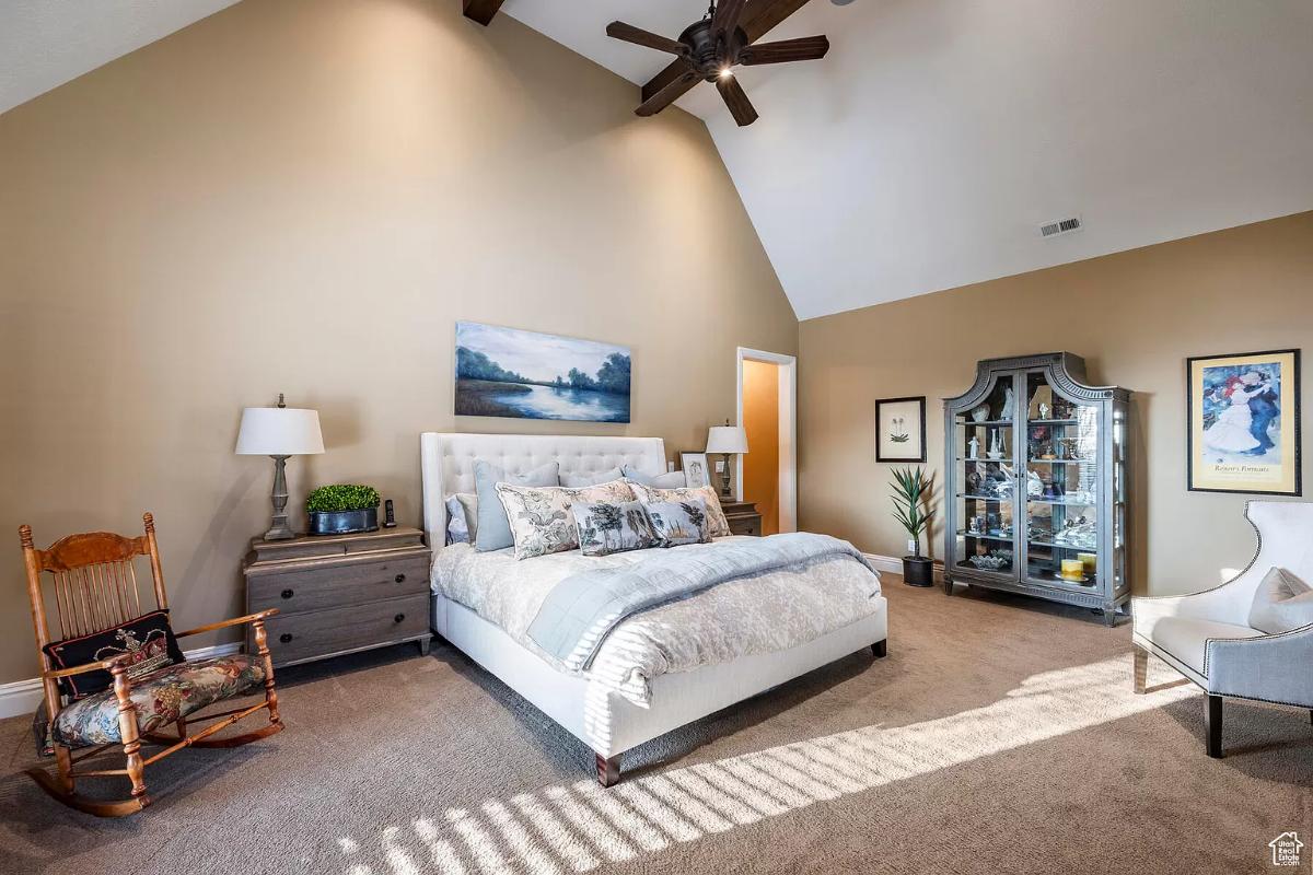 Bedroom with carpet flooring and a large bed.