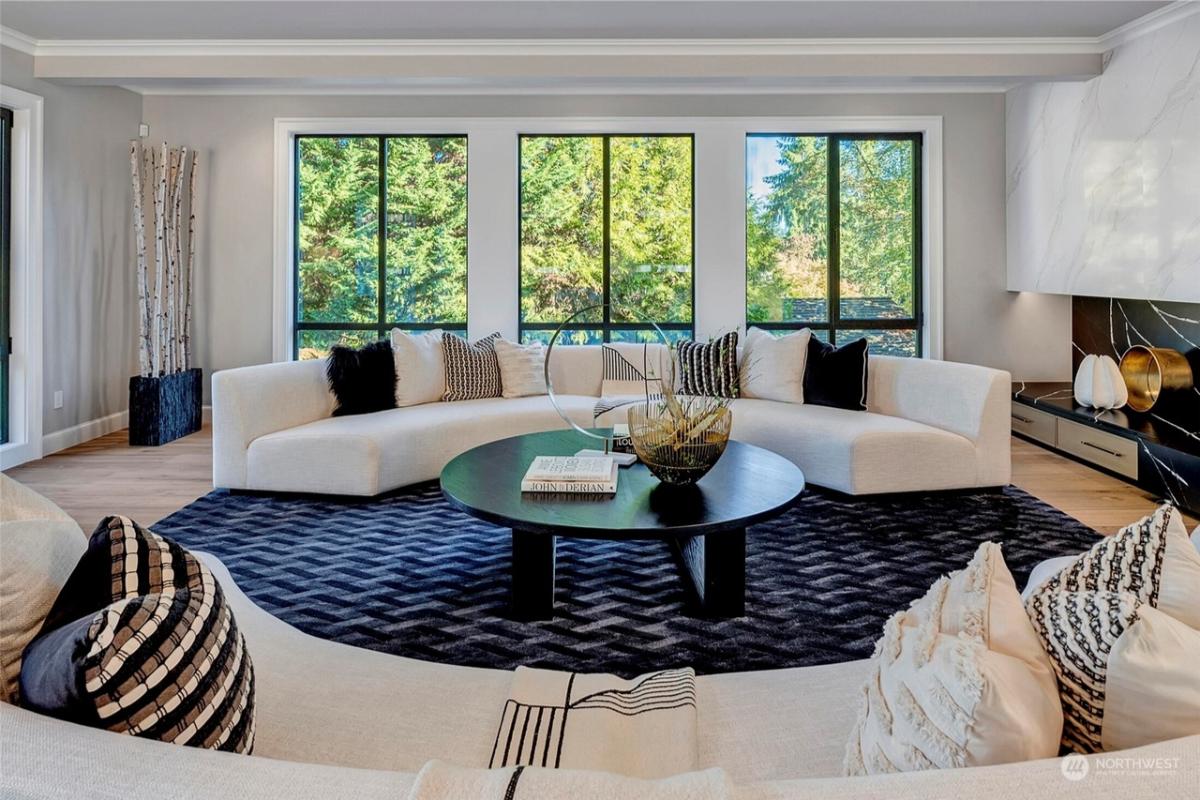 Living room with circular couches and glass windows.