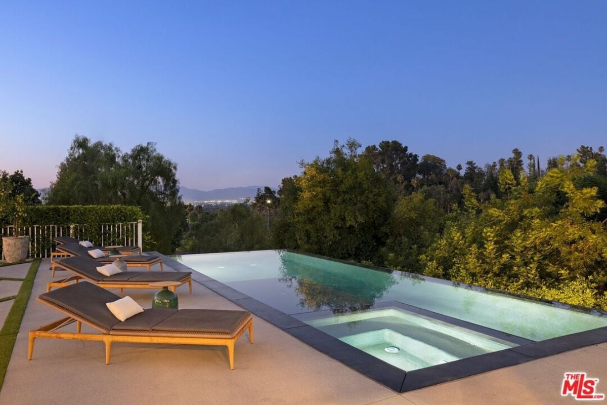 A swimming pool with comfy chairs.