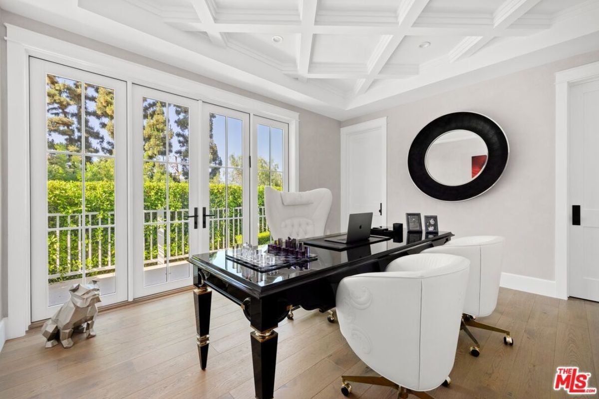 A home office with a mirror and a desk with chairs.
