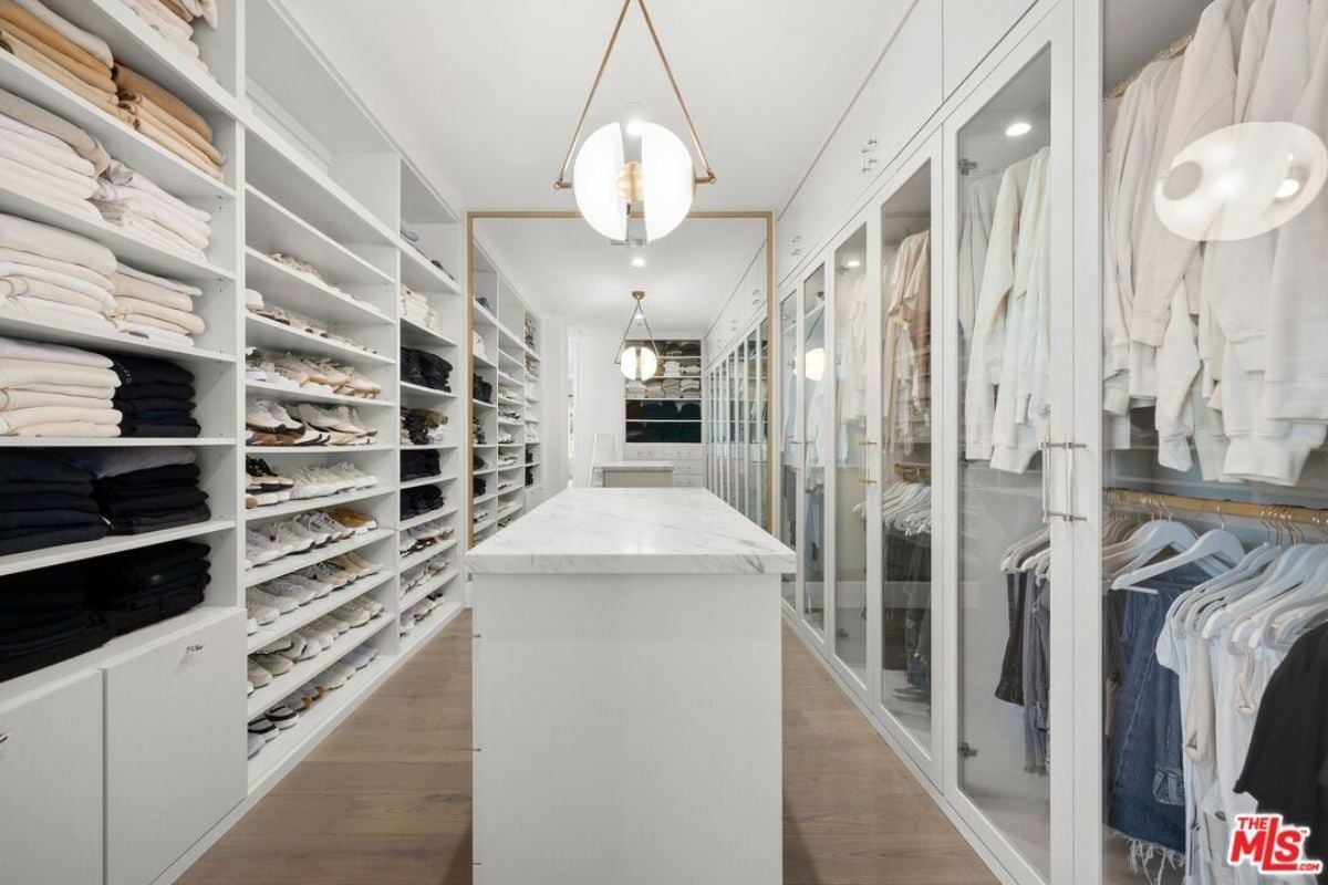 A walk-in closet with a center island and cabinets.