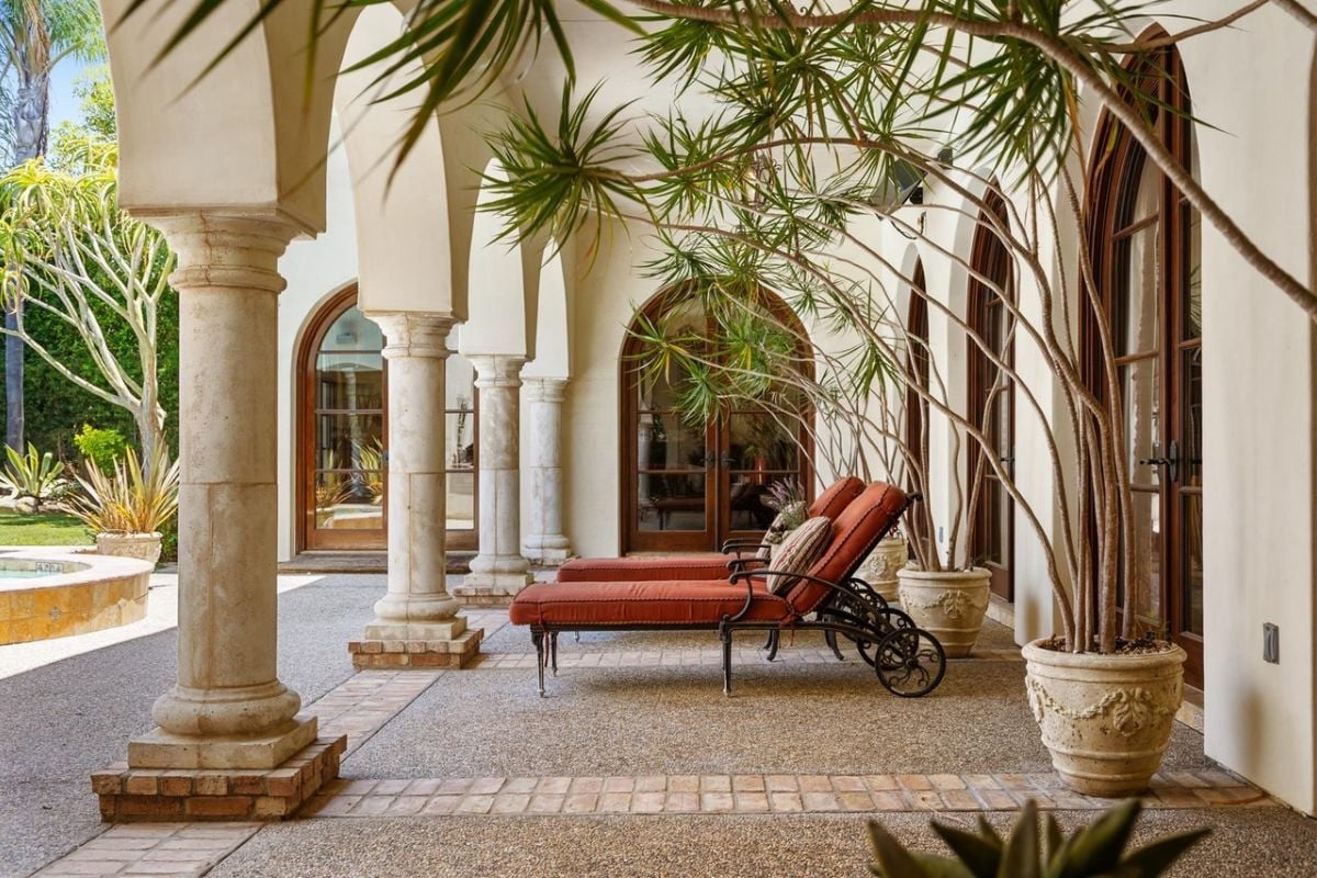 A porch adorned with potted plants and chairs.