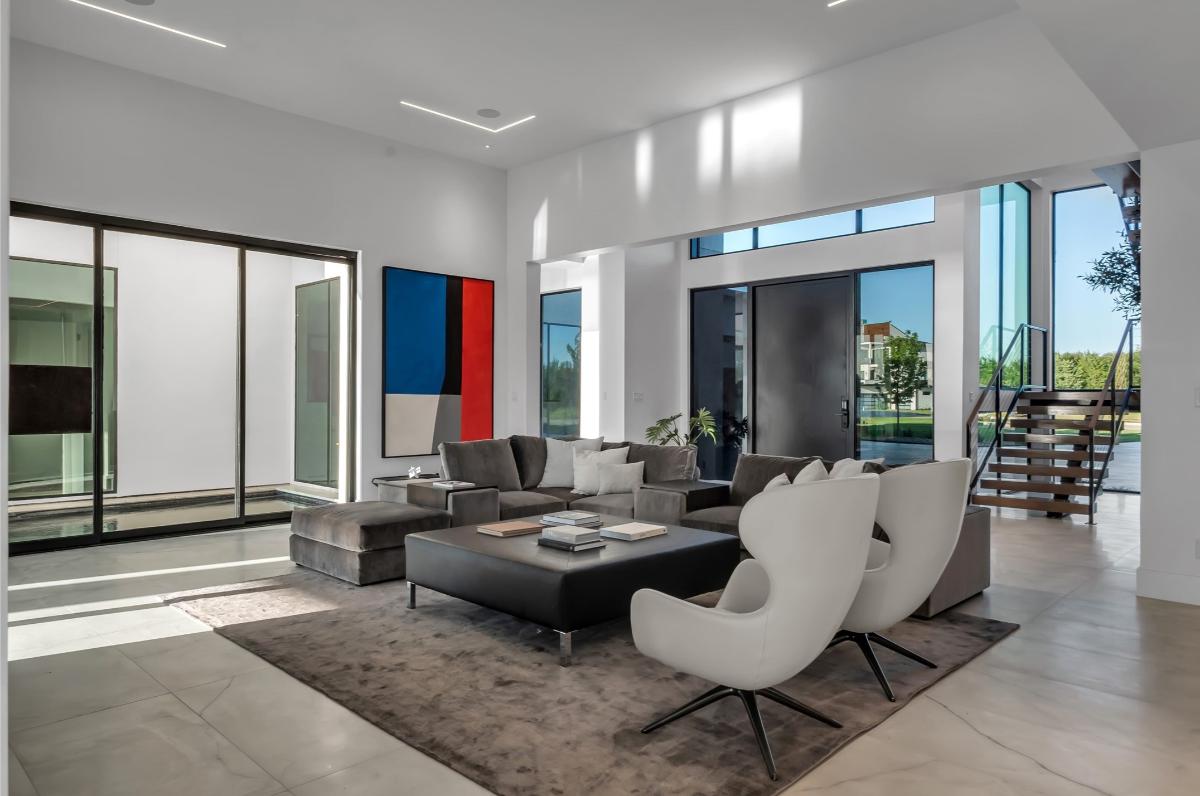 Living room with ceramic tile flooring, couches and custom lighting.