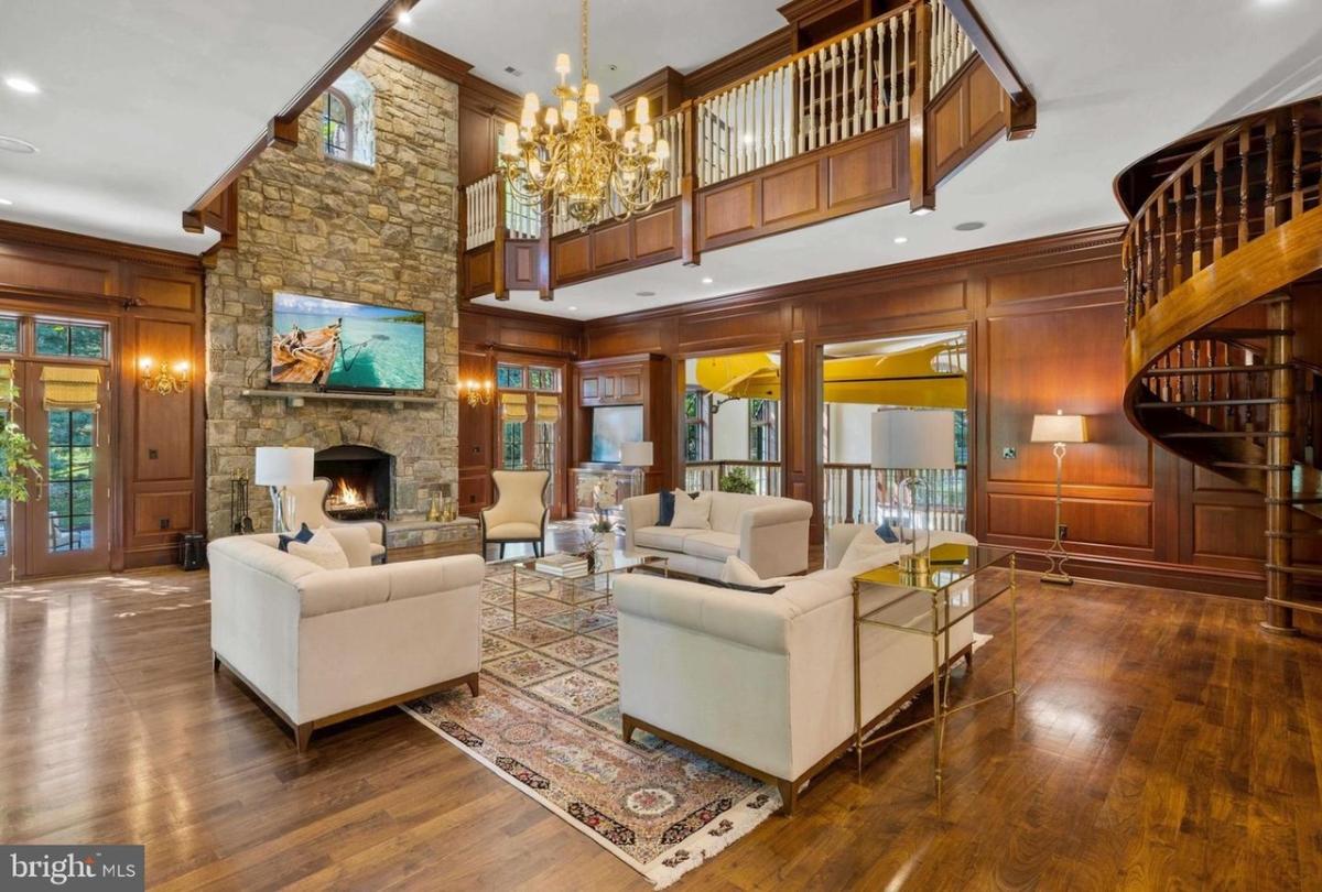 Living room with couches, a fireplace and a chandelier.