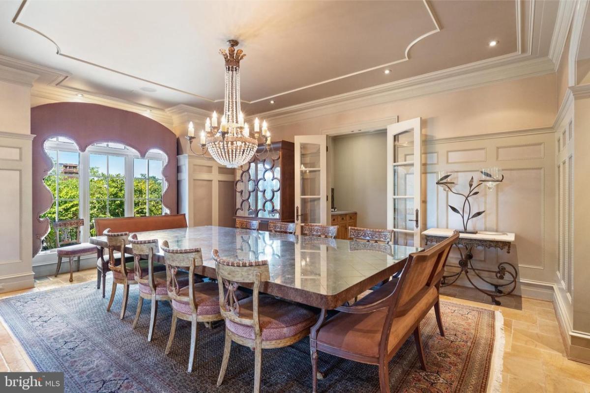 Dining room with a large table and a chandelier.