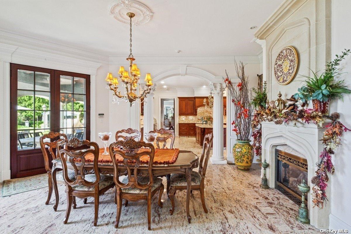 Dining room with a fireplace and a chandelier.