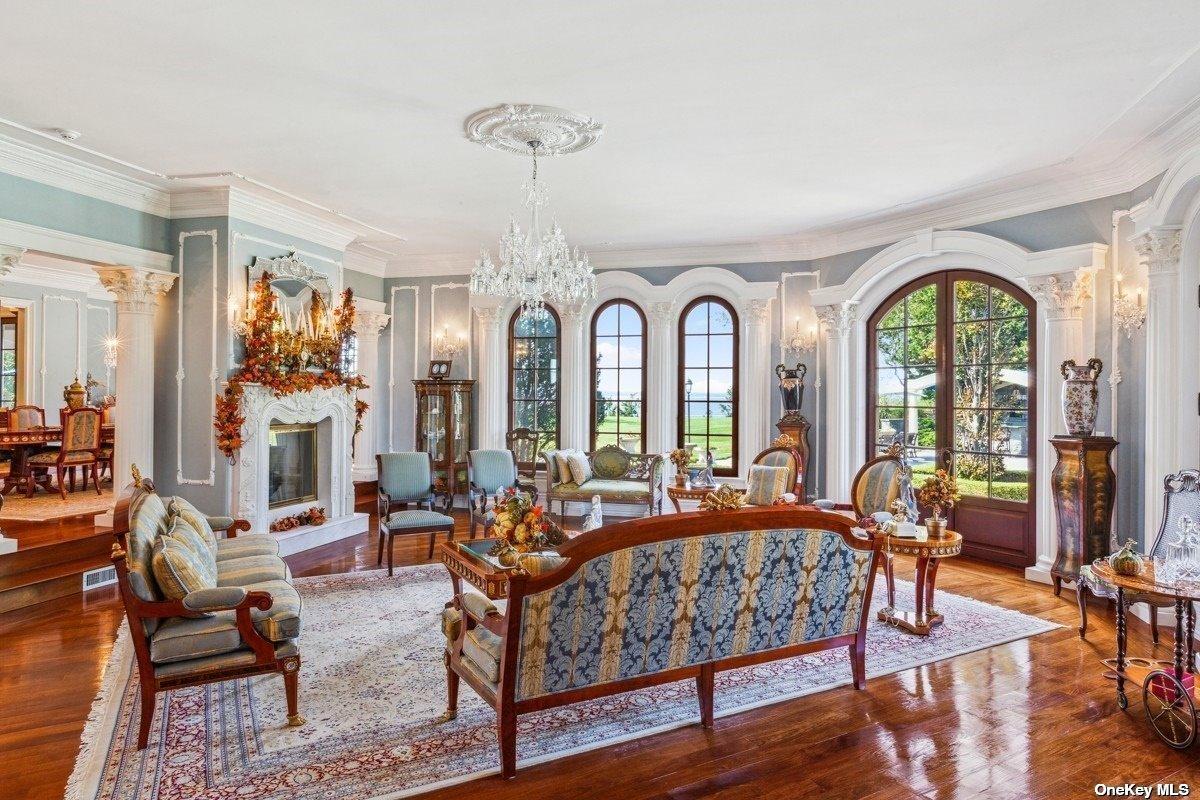 Living room with couches, a fireplace and glass doors.