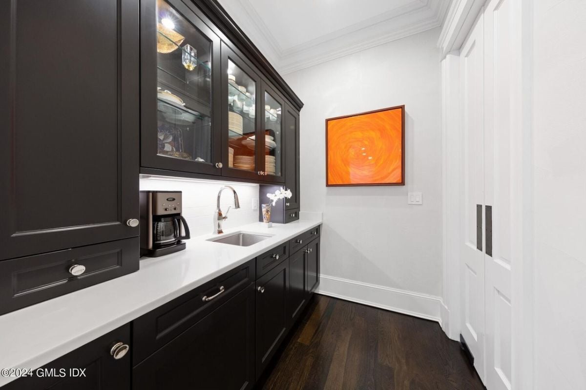 A narrow kitchen with a countertop, sink, and cabinets.