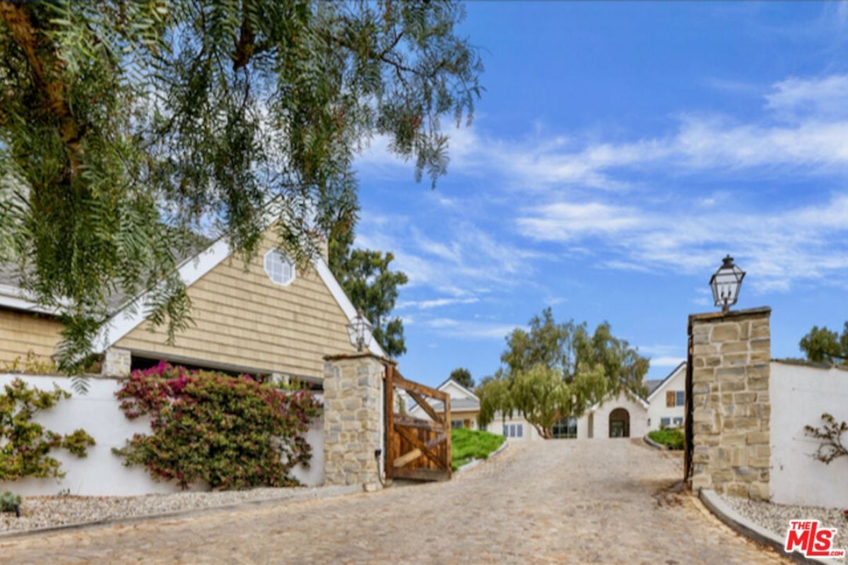 A front gate entry featuring a wooden gate.