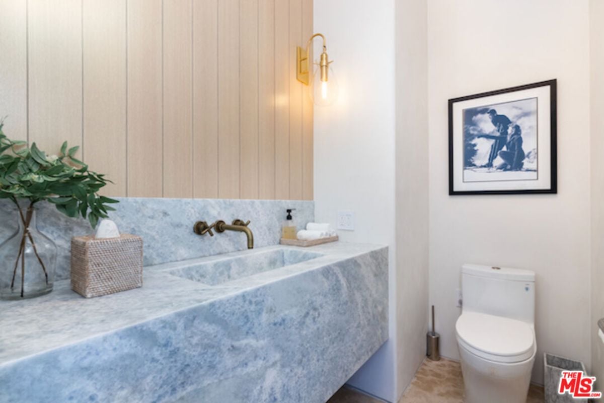 The bathroom features a vanity and toilet.