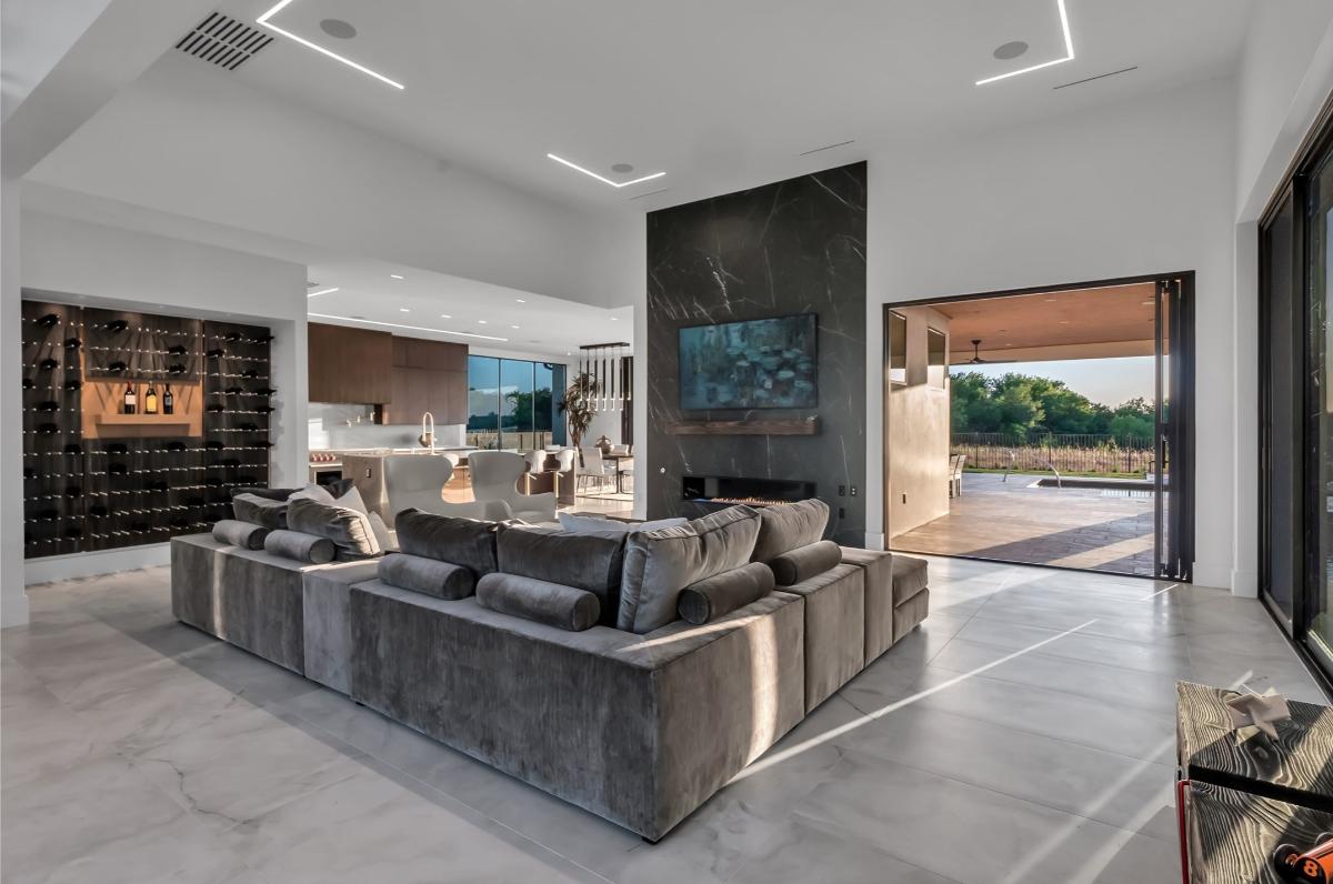 Living room with ceramic tile flooring, couches and custom lighting.