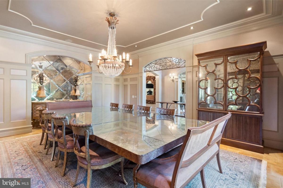 Dining room with a large table and a chandelier.