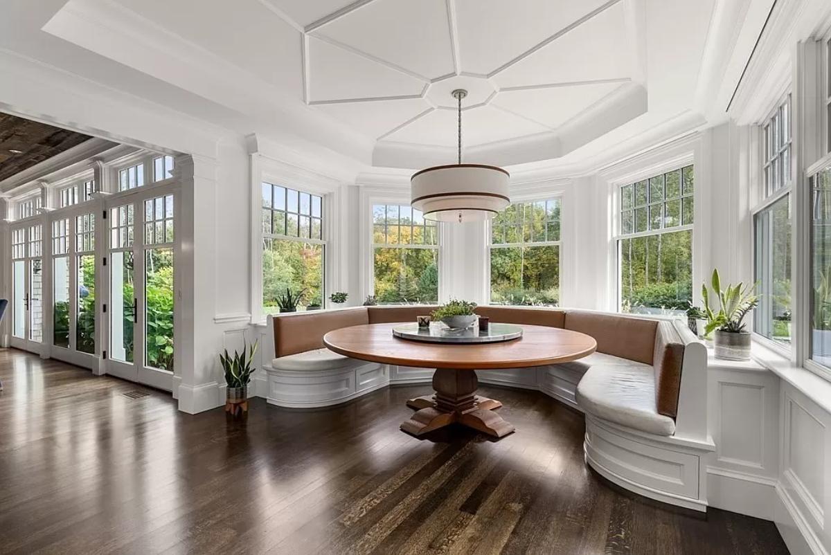 Breakfast nook with a round wood table.