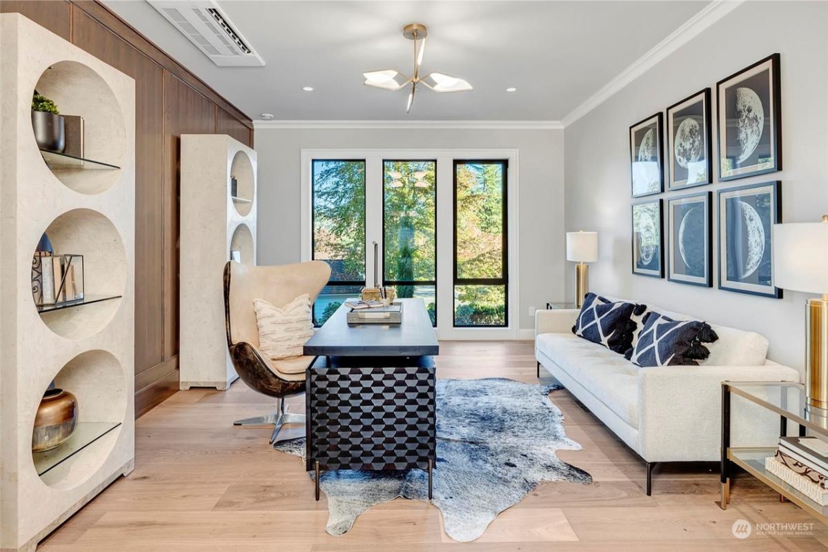 Home office with hardwood floors and a couch.
