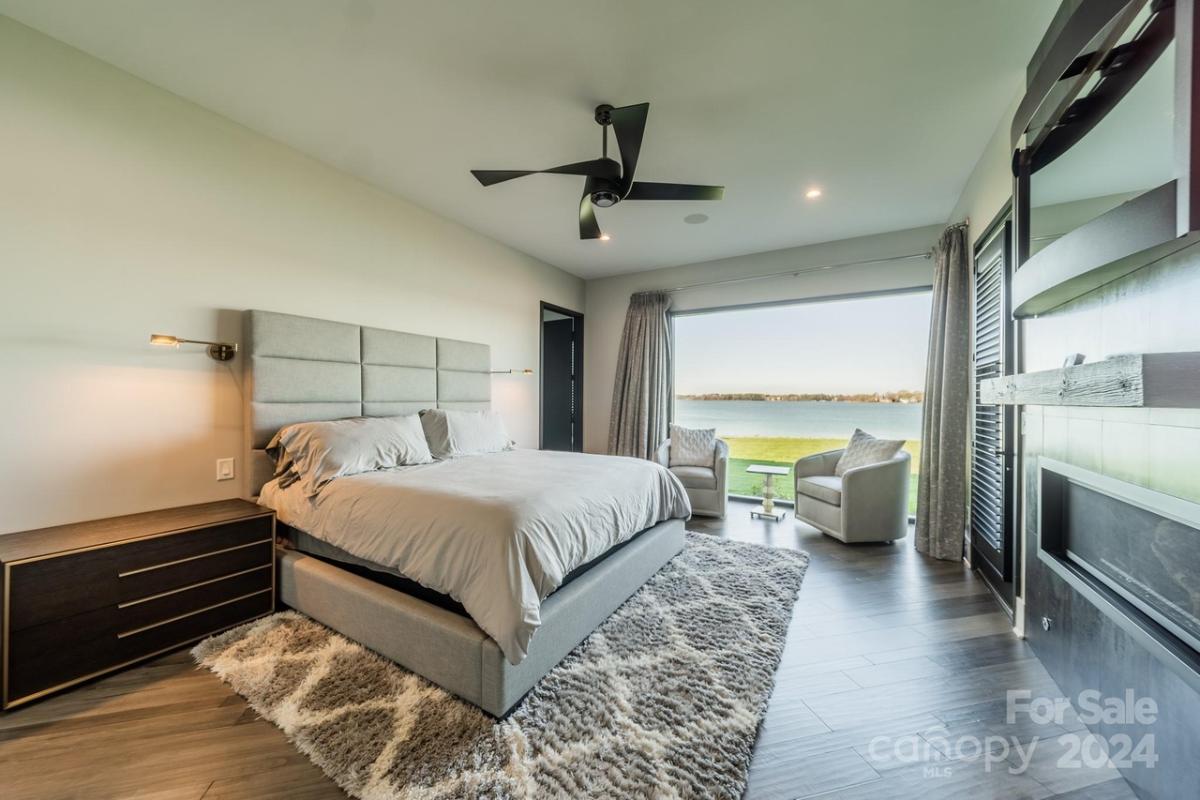 Bedroom with hardwood floors, fireplace and glass walls.