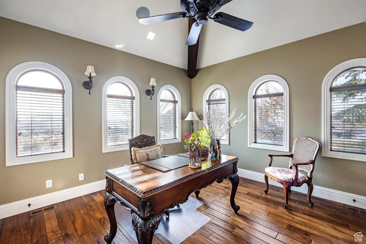 Home office with hardwood floors and glass windows.