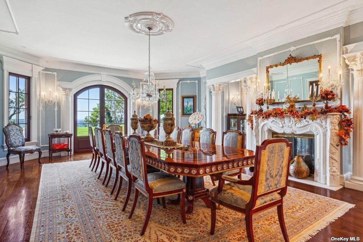 Formal dining room with a fireplace and a chandelier.